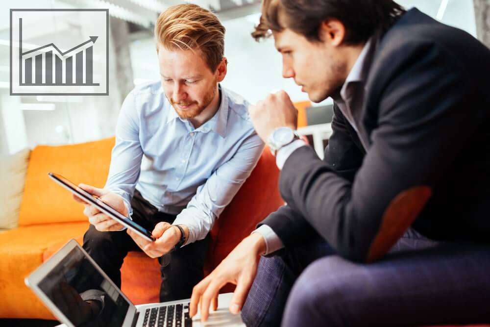 Two business men study social media retargeting on a tablet